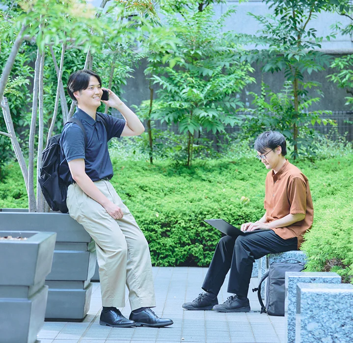 緑豊かな屋外スペースで働くエンジニア。柔軟な働き方ができる職場環境。