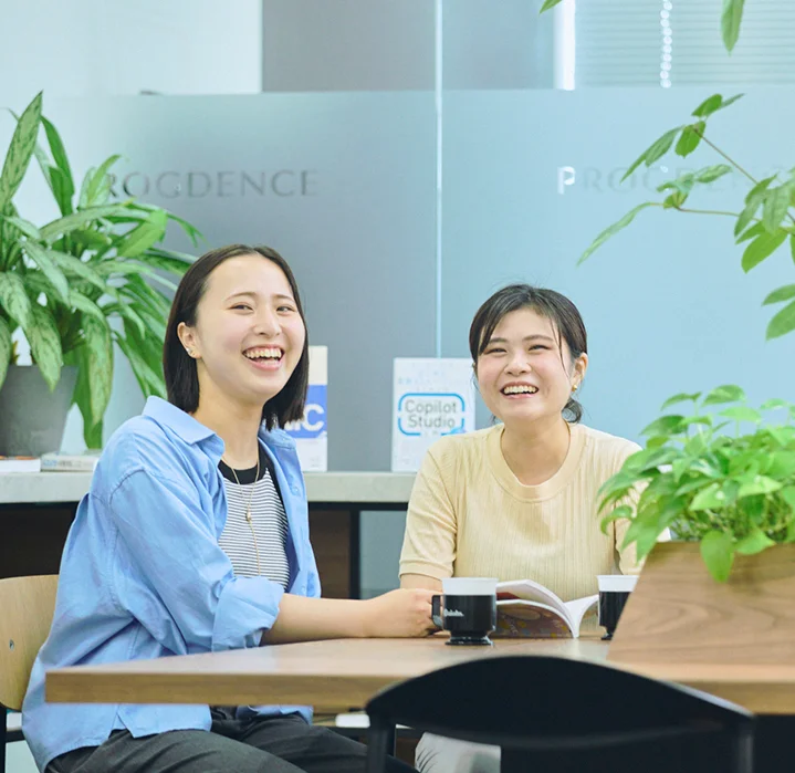 オフィスで談笑する女性コンサルタント。社内の和やかな雰囲気が伝わる一枚。