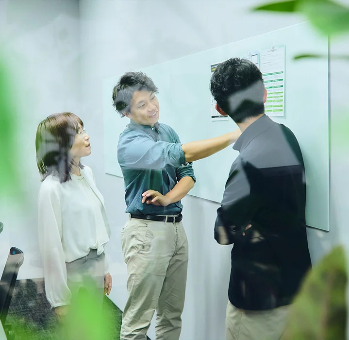 ホワイトボードを使ってプロジェクトの計画を立てるコンサルタントチーム。