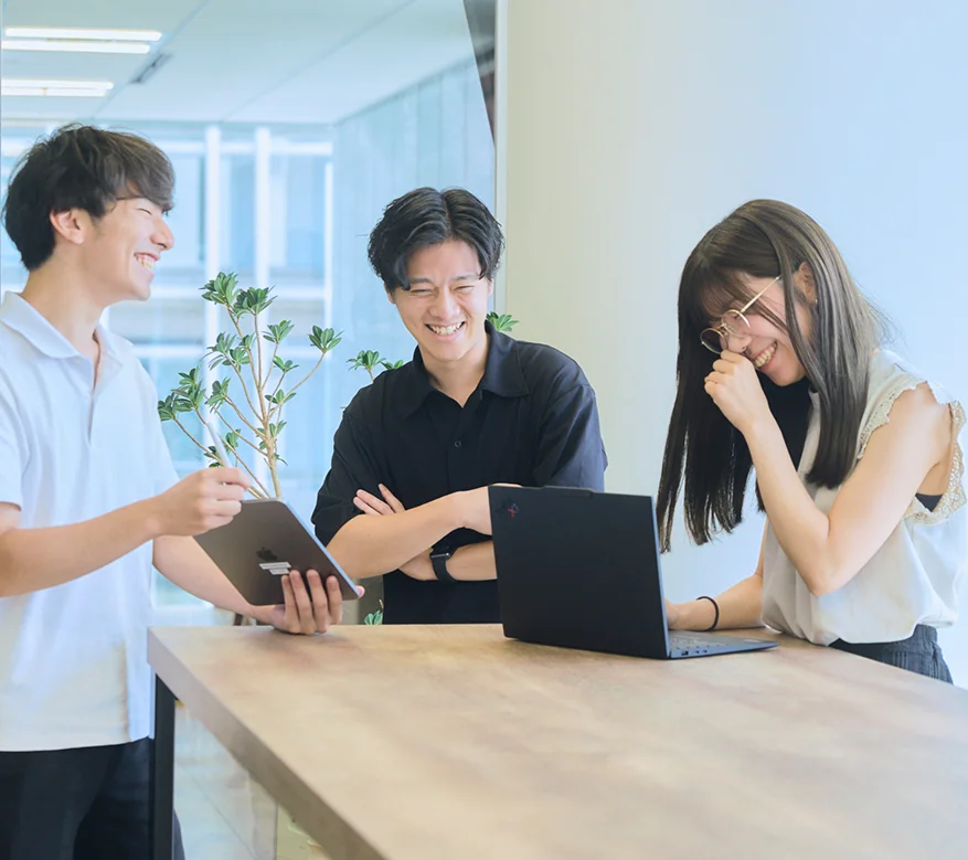 チームでアイデアを出し合い、活気に満ちたディスカッションを行う社員たち。一体感のある明るい職場。